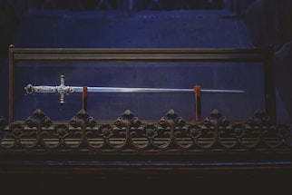 black and gold cross on black metal fence