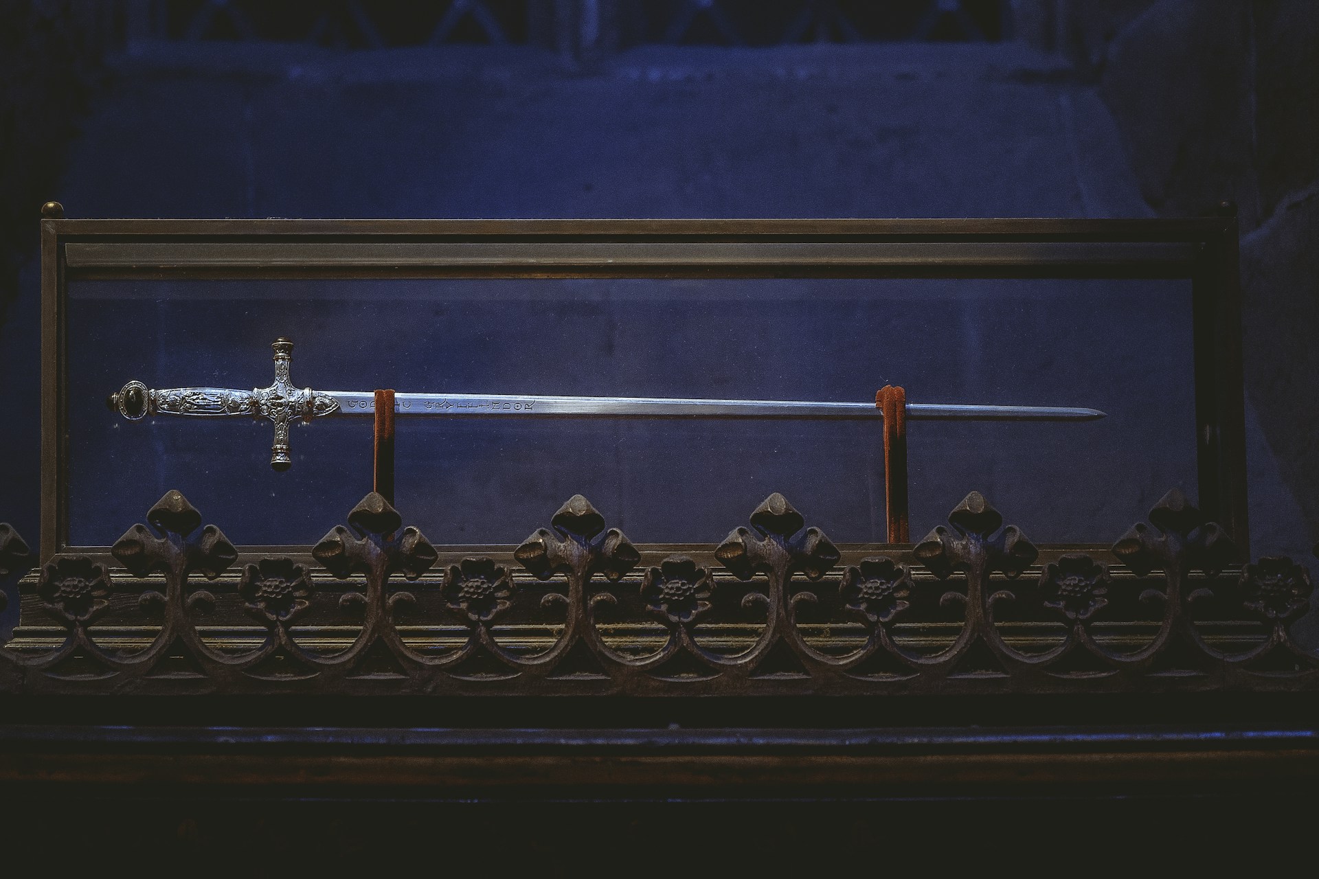 black and gold cross on black metal fence