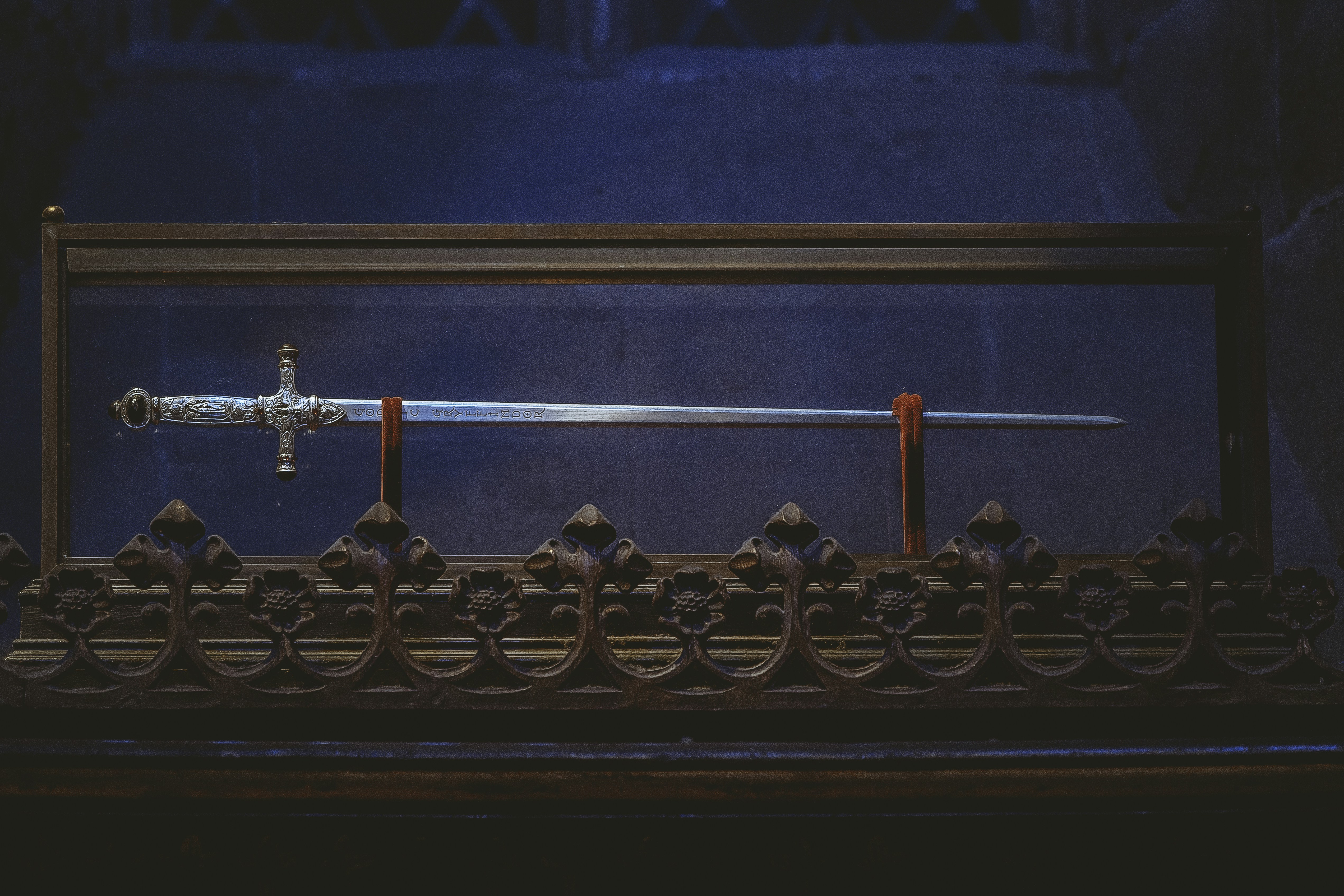 black and gold cross on black metal fence