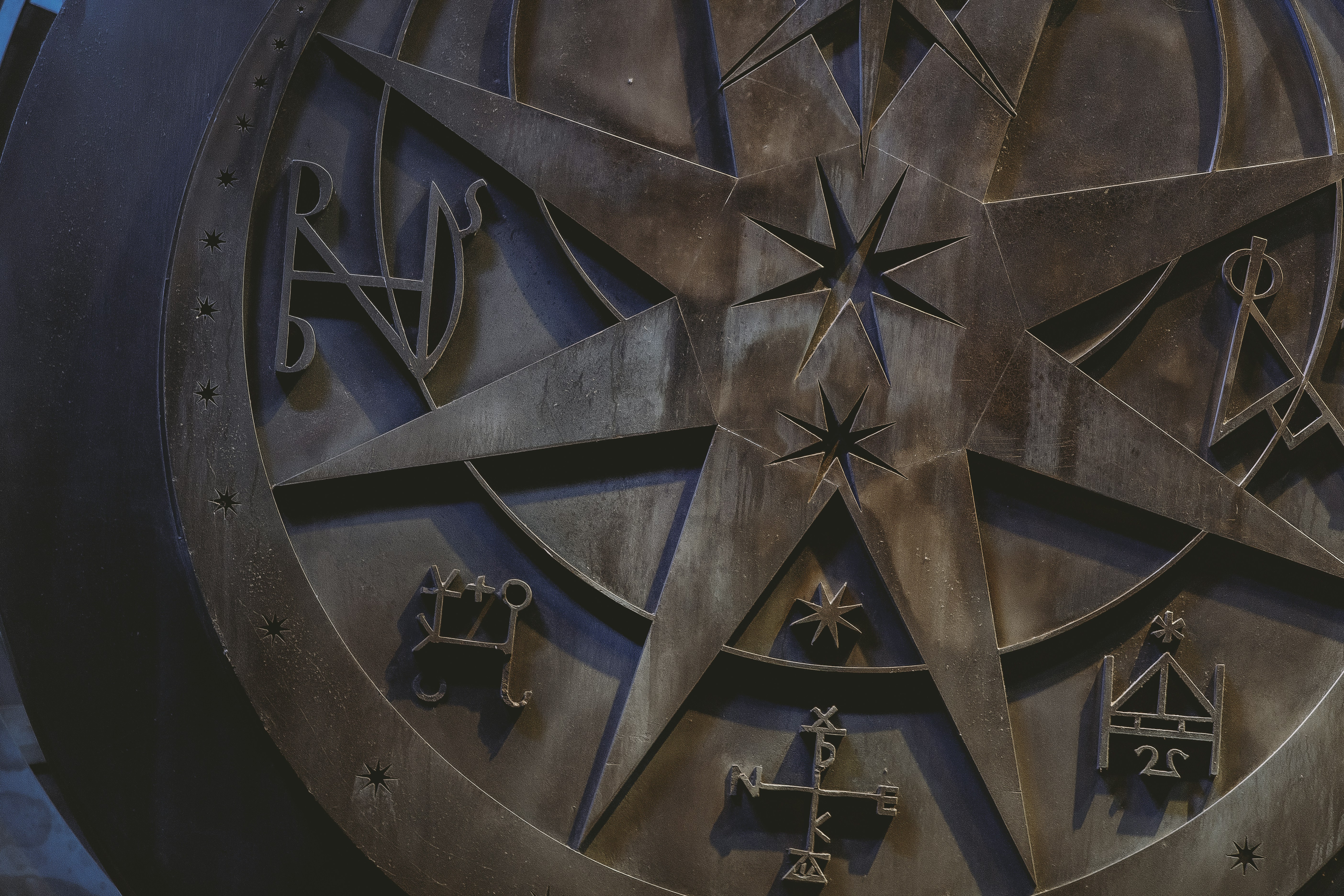 Brown and black round decor resembling a zodiac wheel