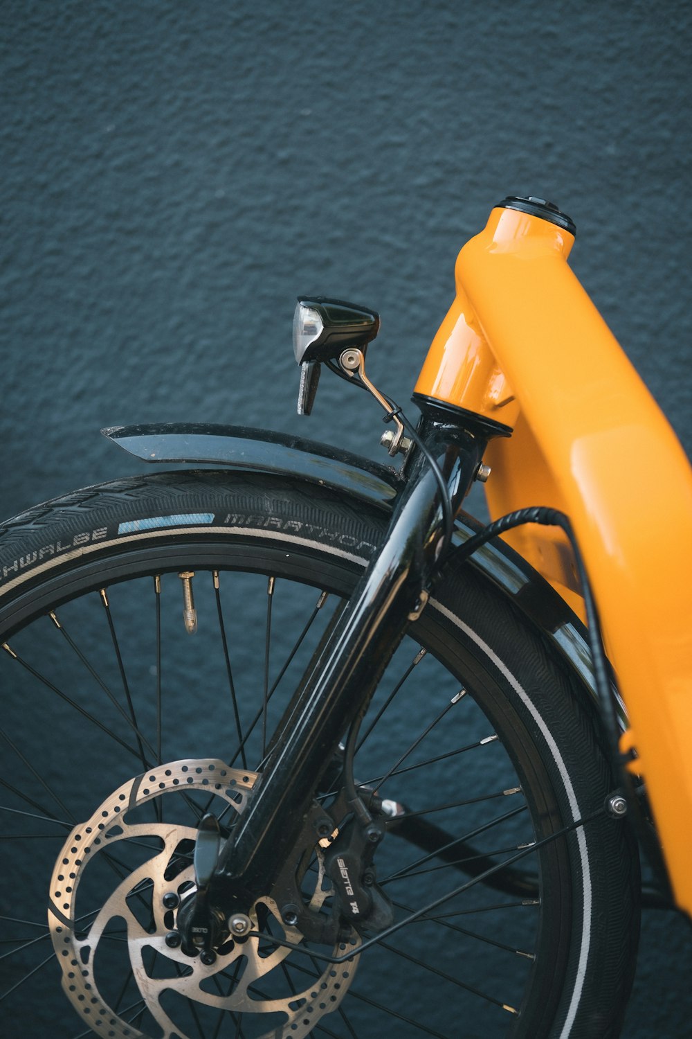 roda de bicicleta preta ao lado do recipiente de plástico amarelo