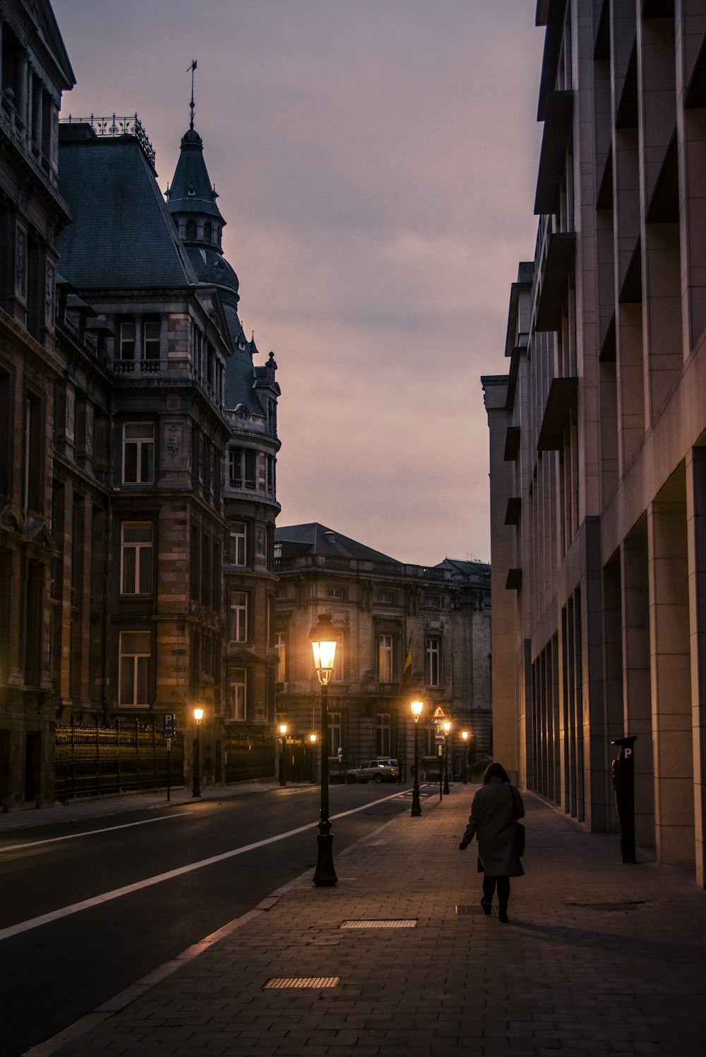 people walking on sidewalk near building during night time