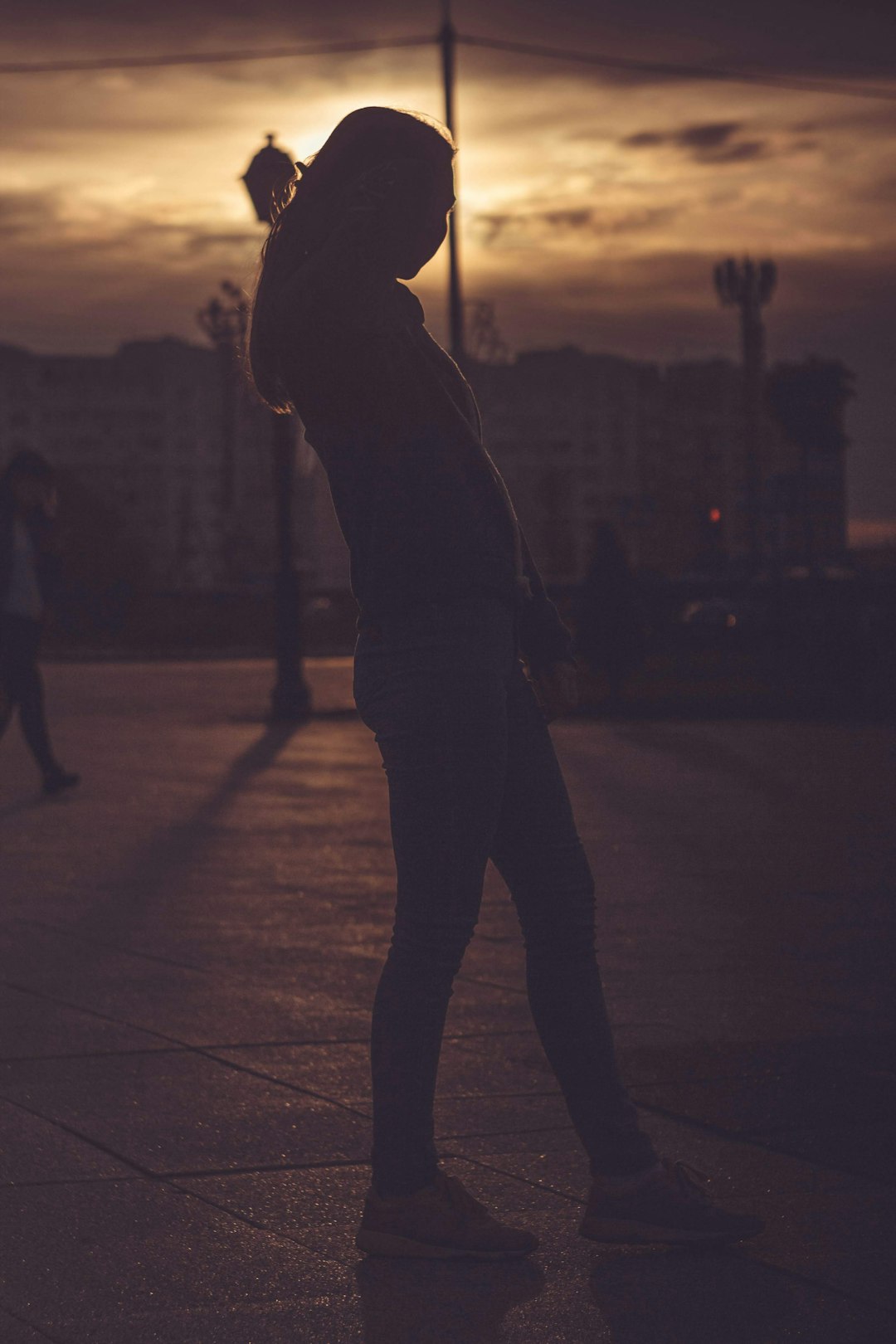 silhouette of person walking on street during night time