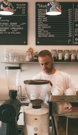 man in white dress shirt standing in front of kitchen counter