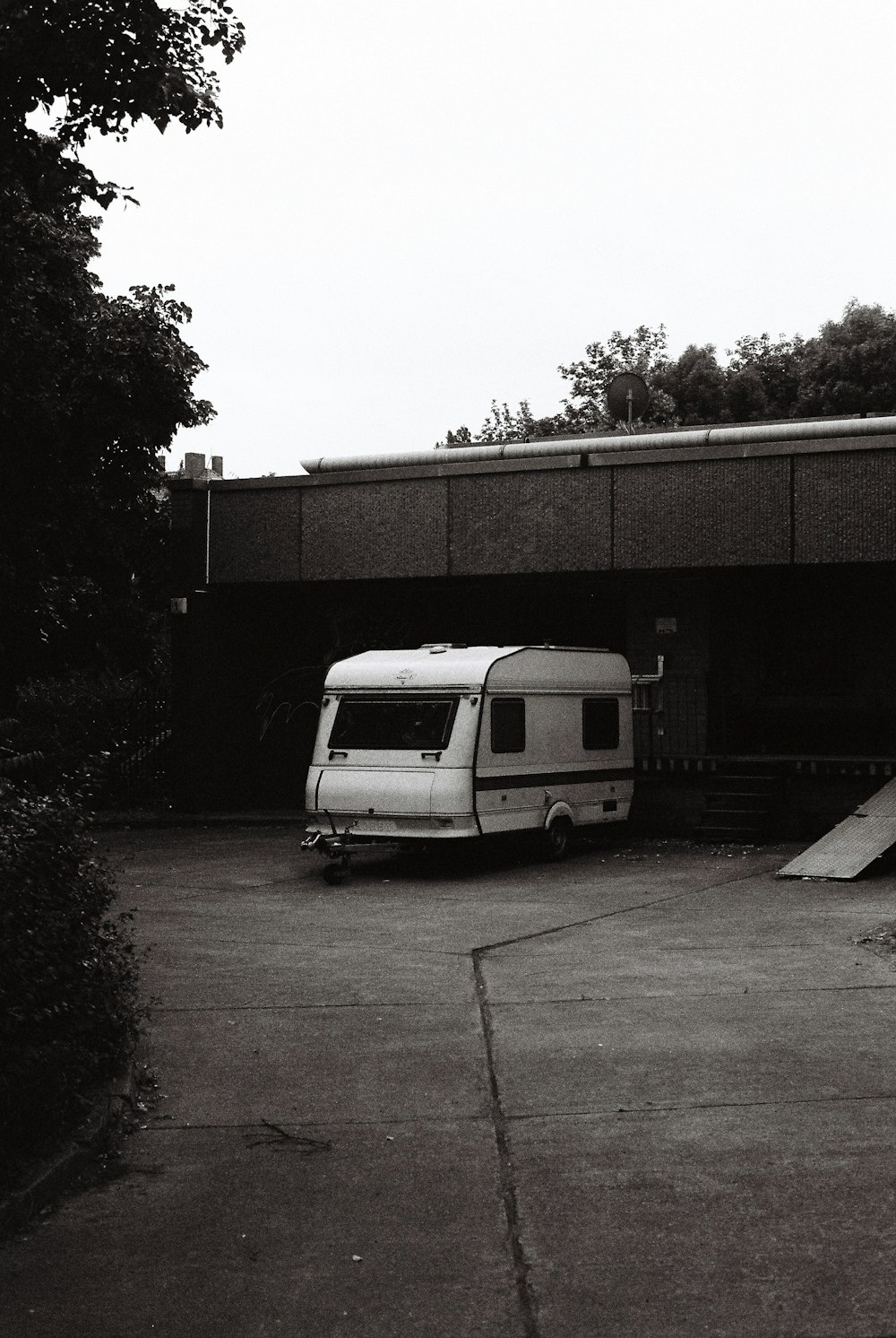 grayscale photo of van parked near building