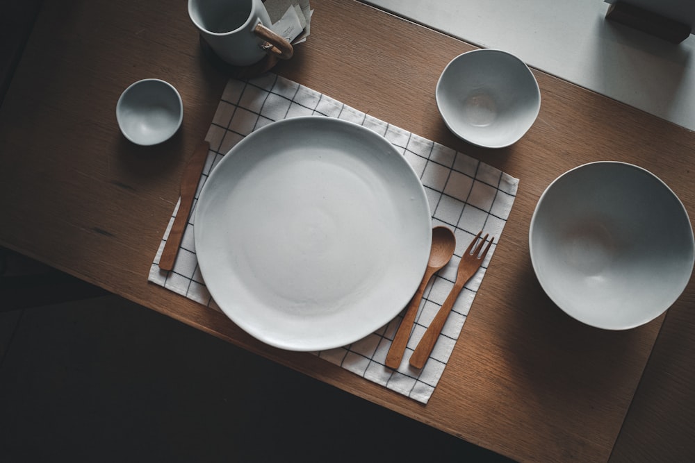 placa redonda cerâmica branca na mesa de madeira marrom