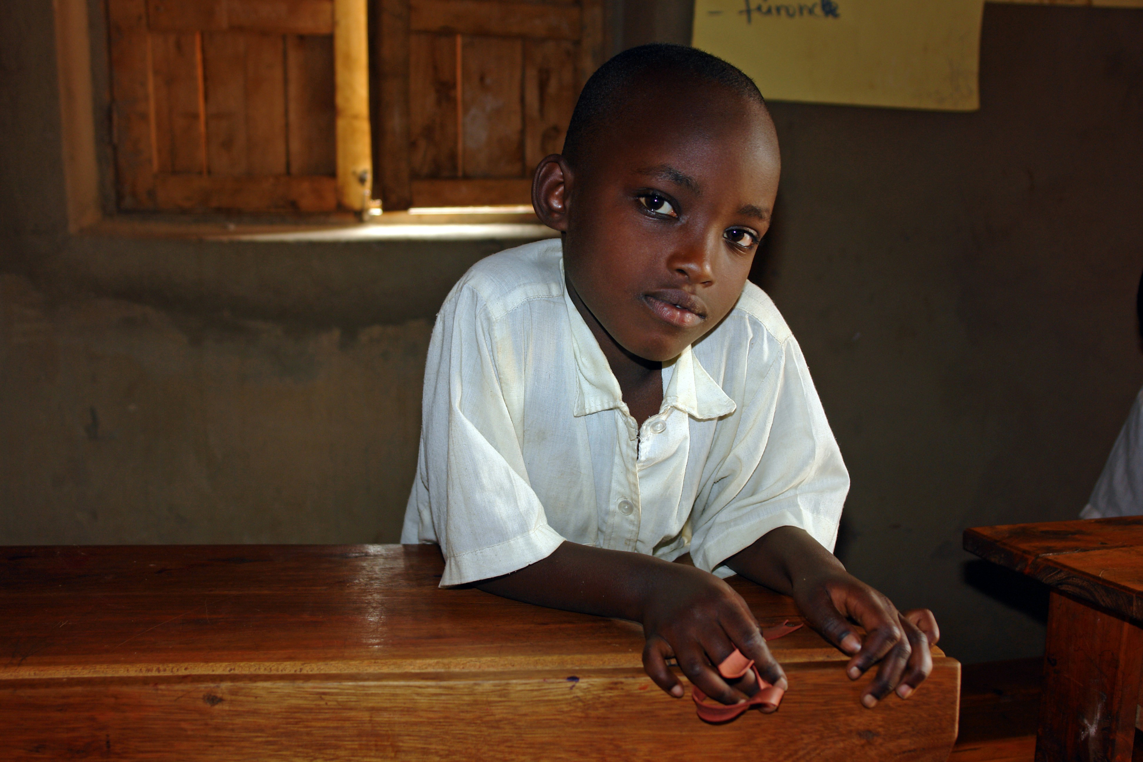 boy in white button up shirt sitting beside brown wooden table