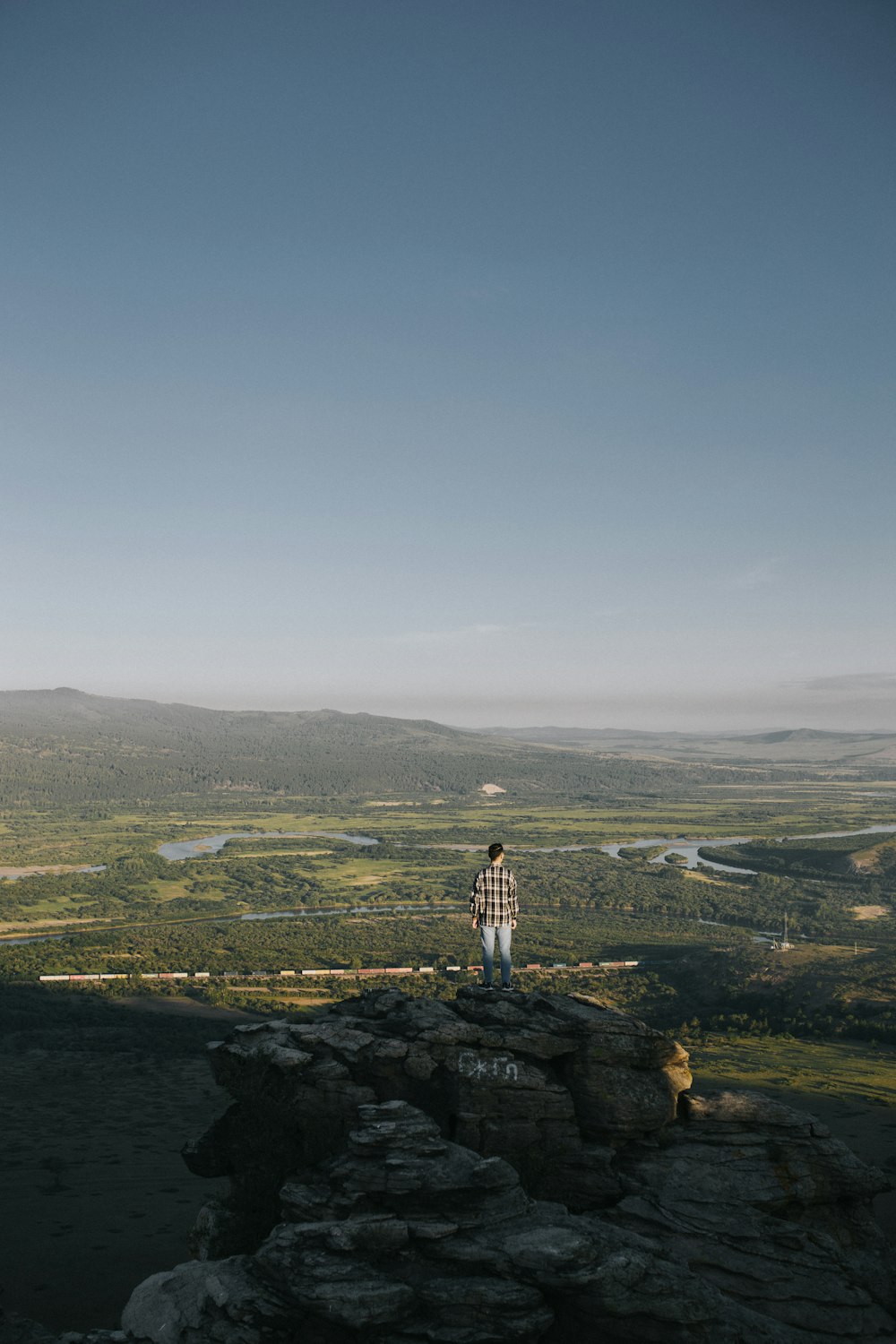 man standing on rock formation during daytime