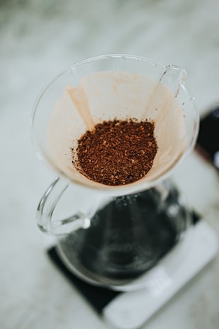 The Hario V60 brewer placed on a scale, mid-pour, highlighting the precision of the process.