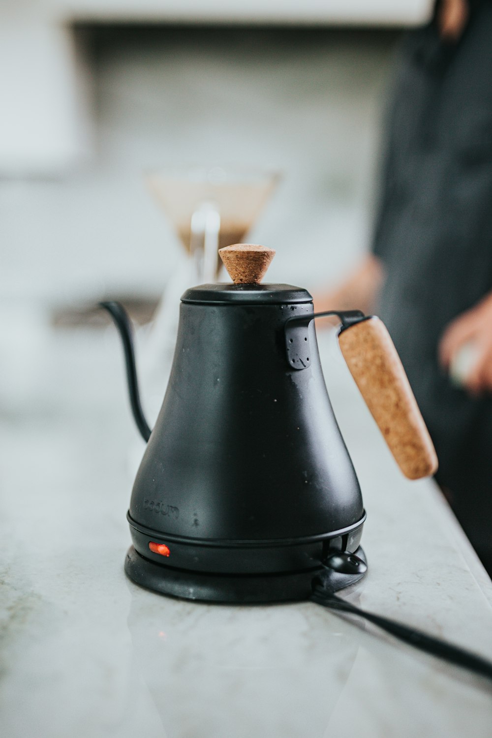 schwarze Keramik-Teekanne auf weißem Tisch