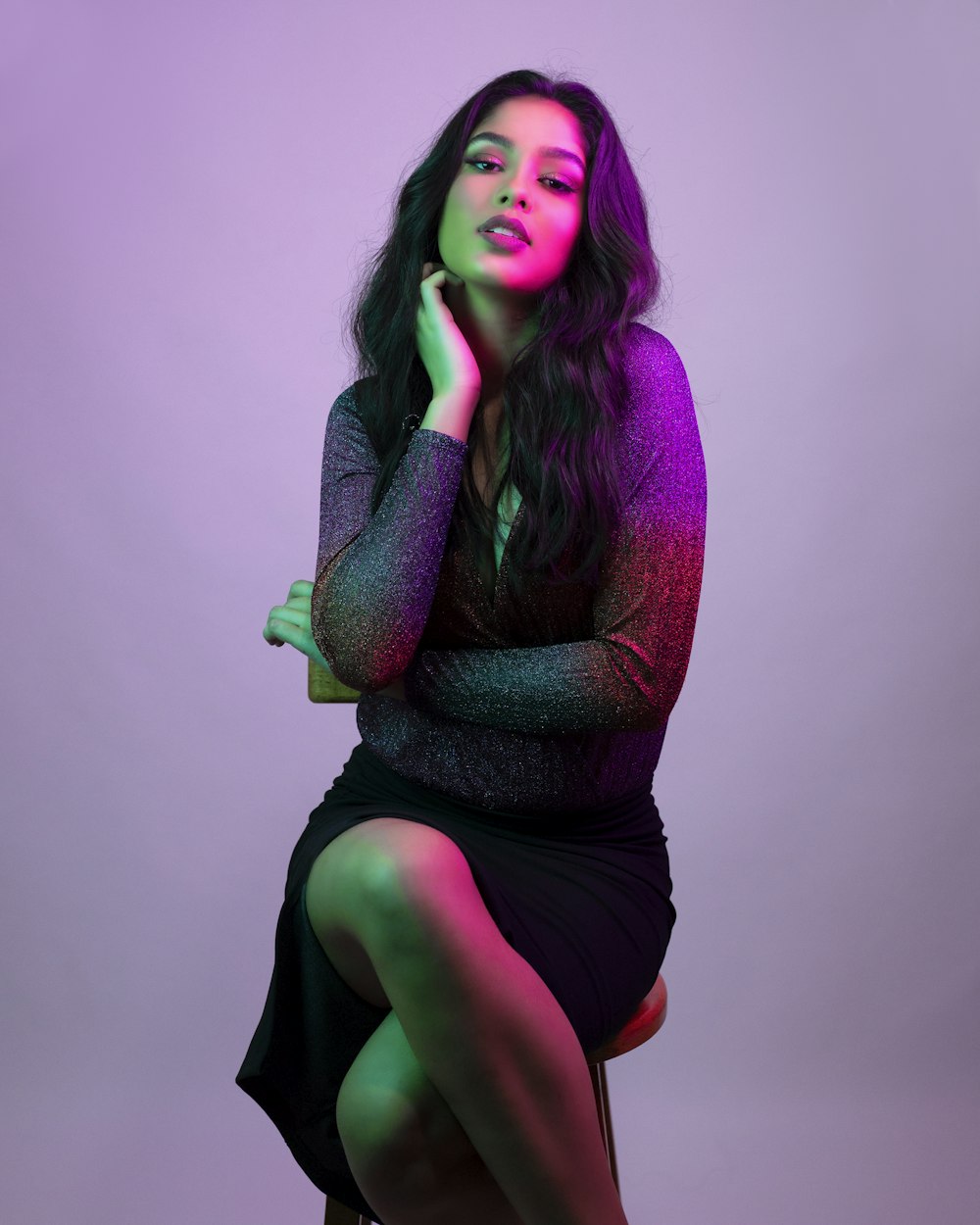 woman in purple knit sweater and black skirt sitting on brown wooden seat