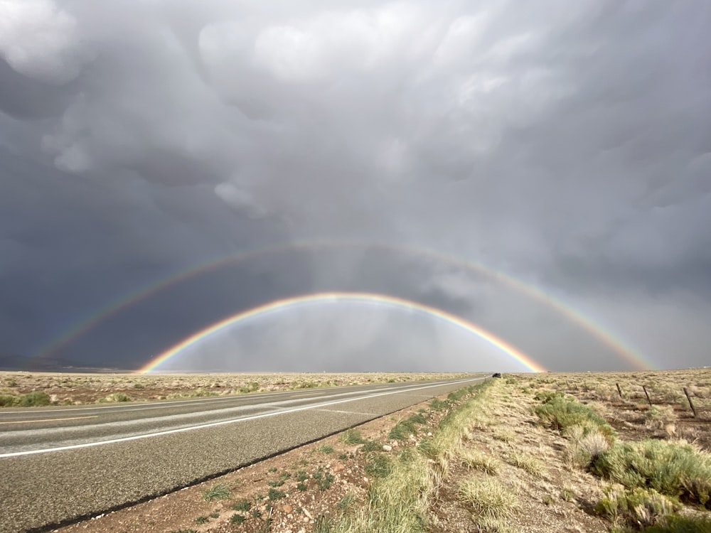 green grass field under rainbow