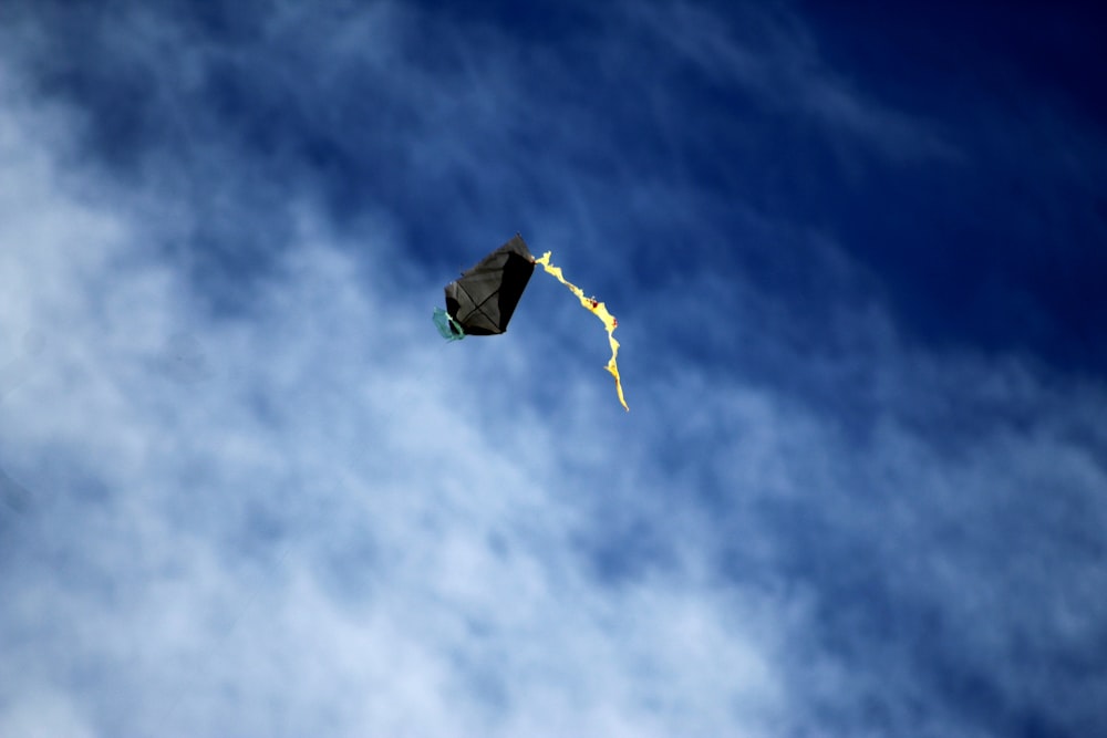 yellow and orange kite flying in the sky during daytime