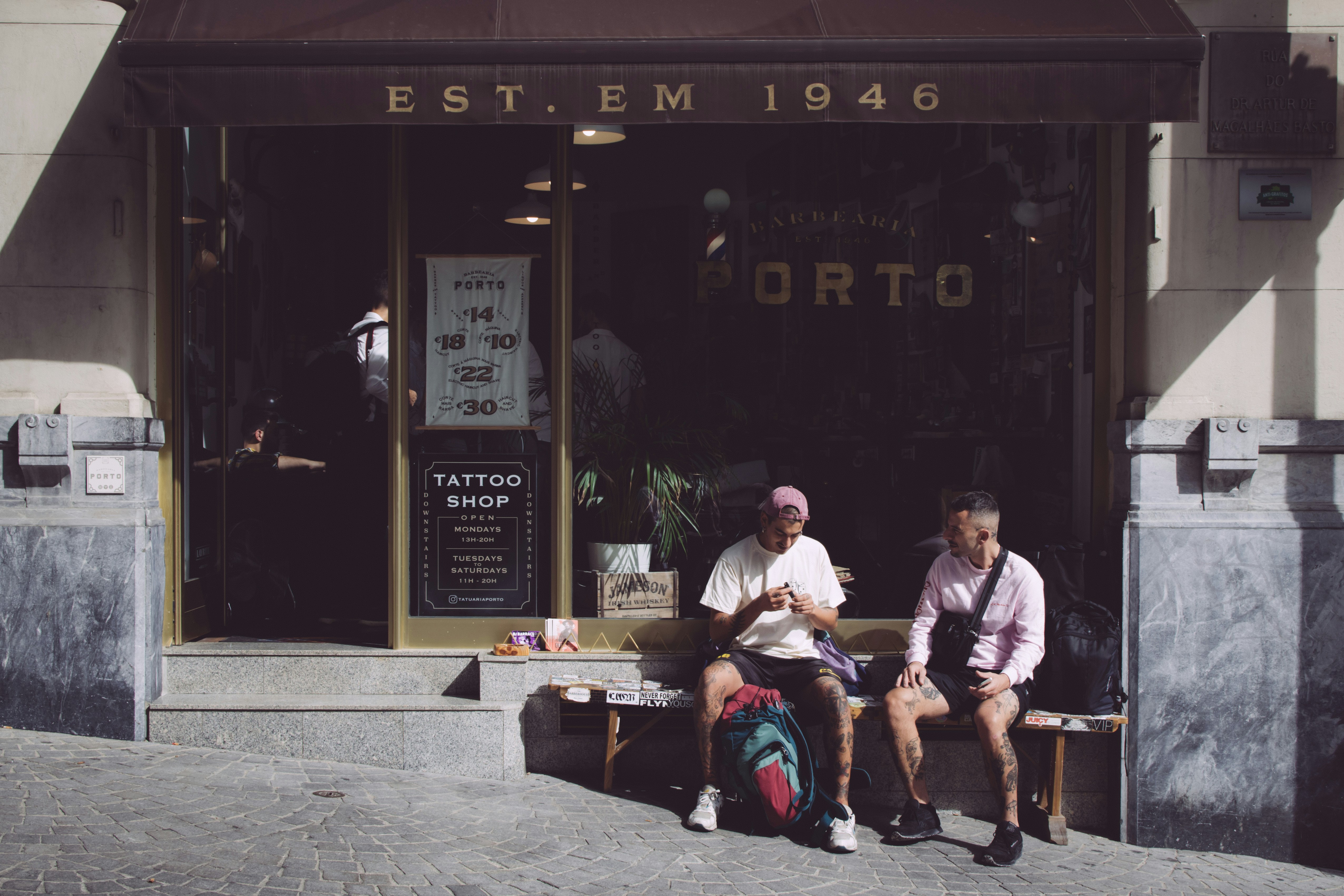 two people sitting in front of a shop