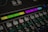 A close-up of an audio mixing console featuring various buttons and labeled controls. The panel includes labels like 'Muziek' and 'Film' with colored backlighting in green, yellow, and purple. Several rows of buttons are visible, each with different functions such as 'Mute' and 'Sel'. The overall look is technical and organized, suggesting a professional audio setup.