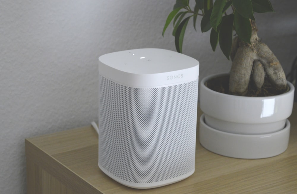 white portable speaker on brown wooden table