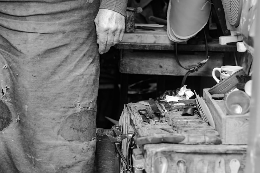 grayscale photo of man in long sleeve shirt holding paint brush