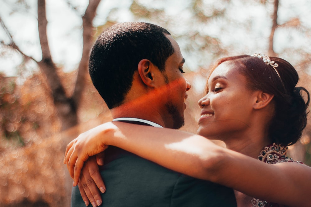 man in black shirt kissing woman in white shirt