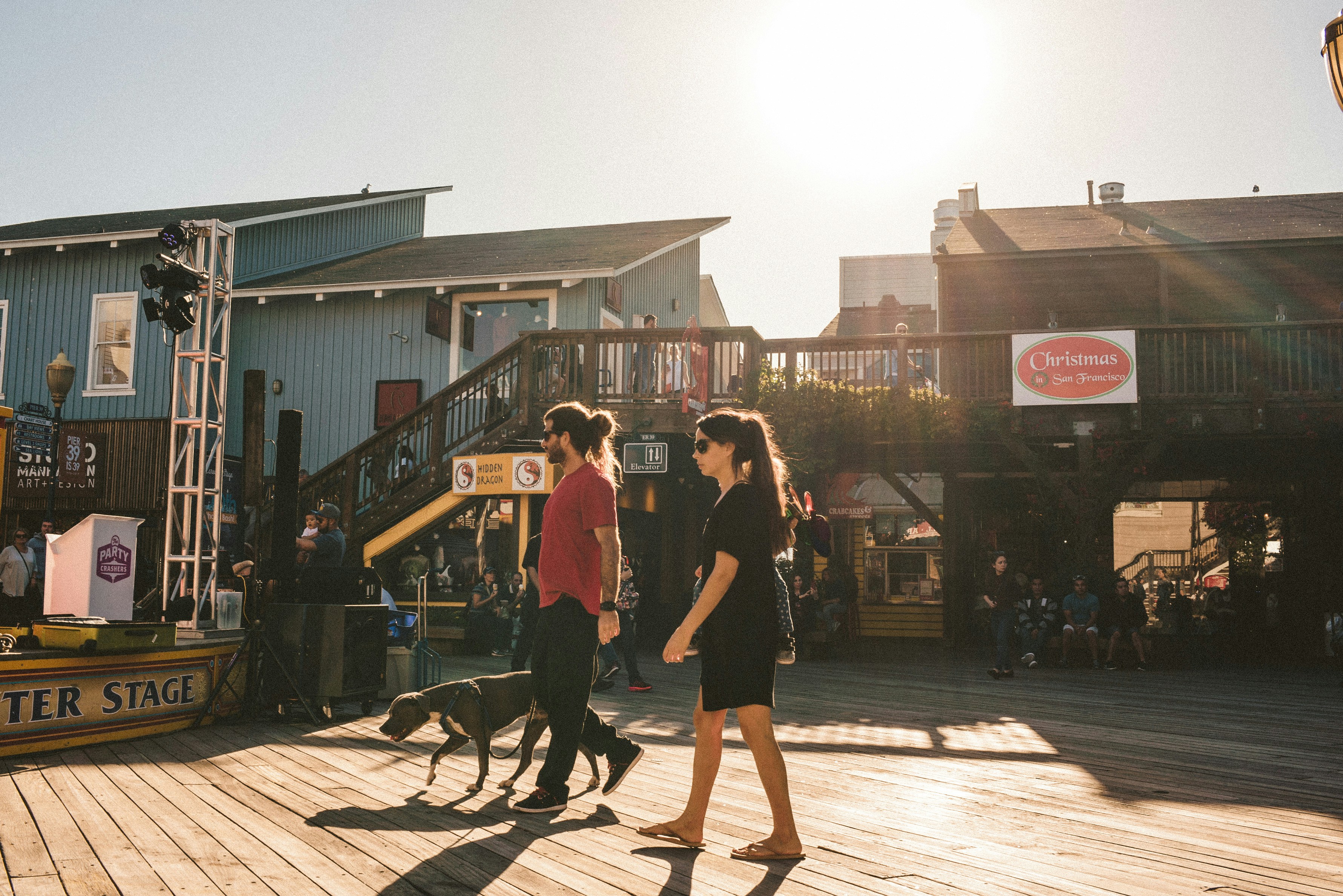 3 women walking on wooden dock during daytime