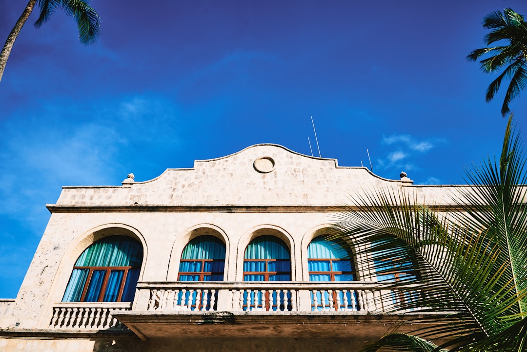 white concrete building near palm trees during daytime