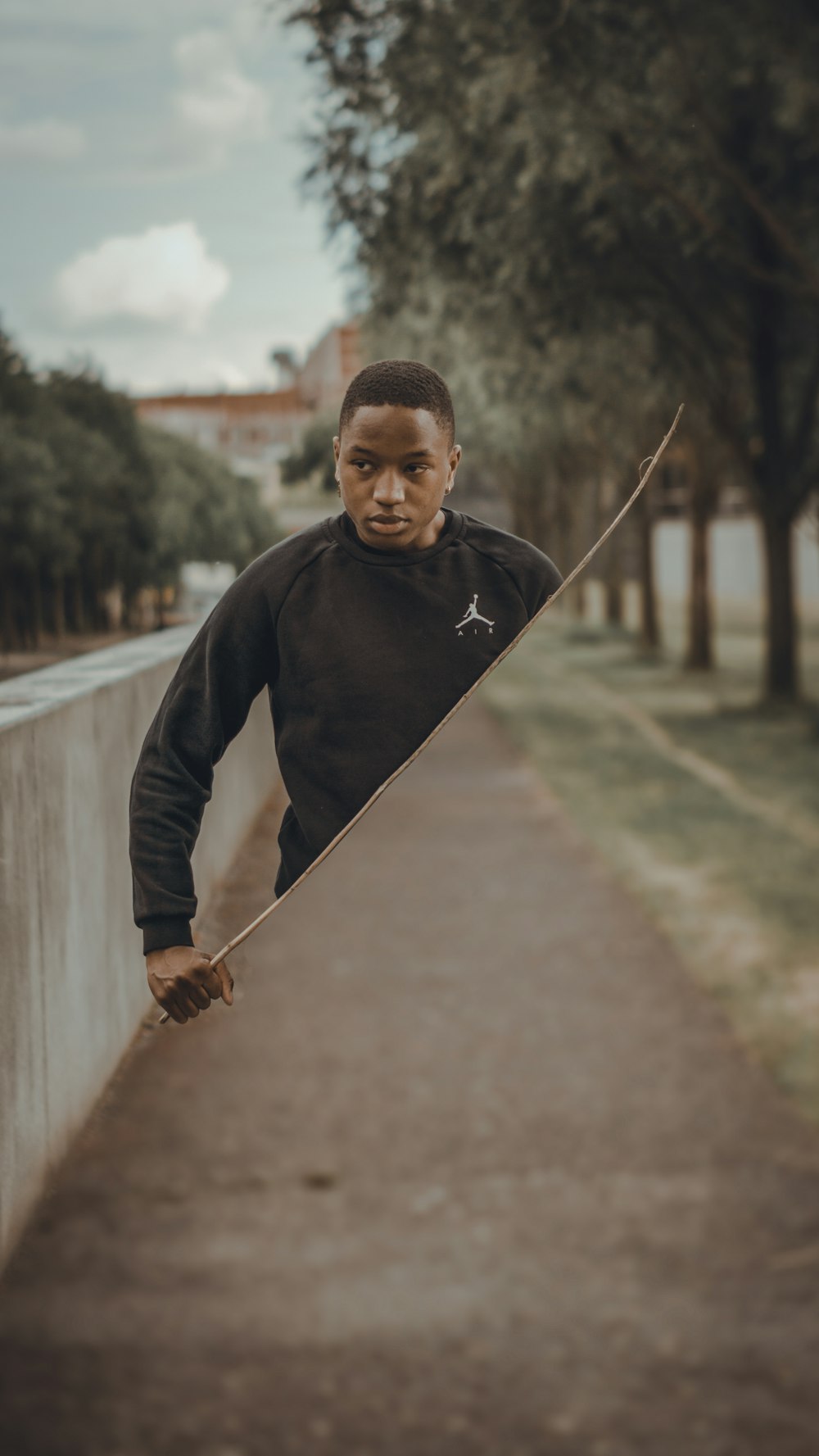 man in black jacket holding a stick