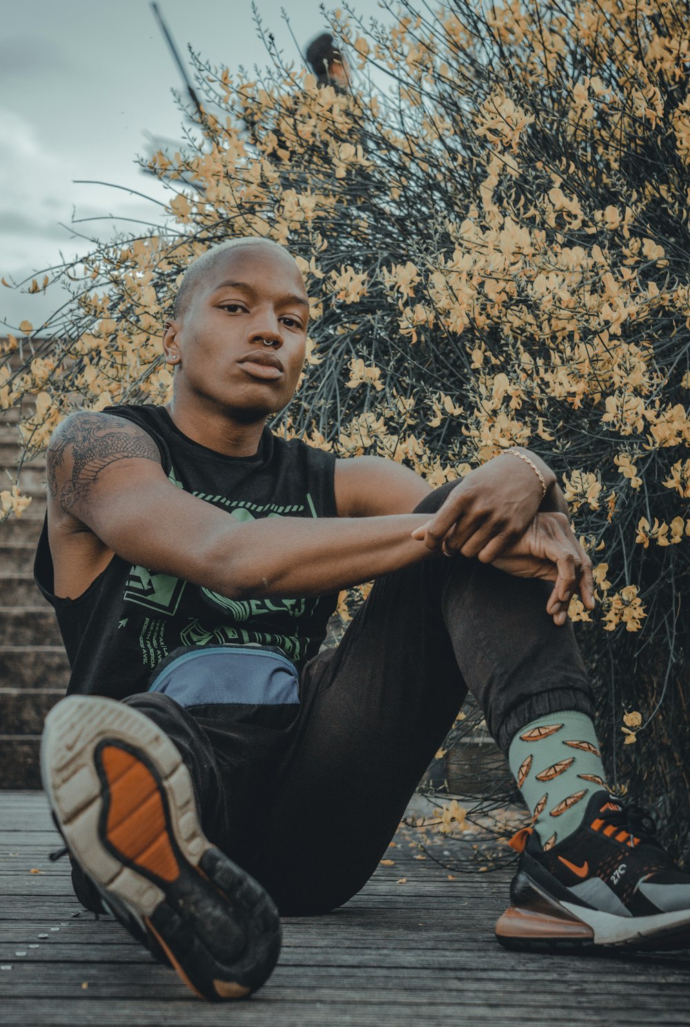 boy in gray crew neck t-shirt and blue denim jeans sitting on brown dried leaves