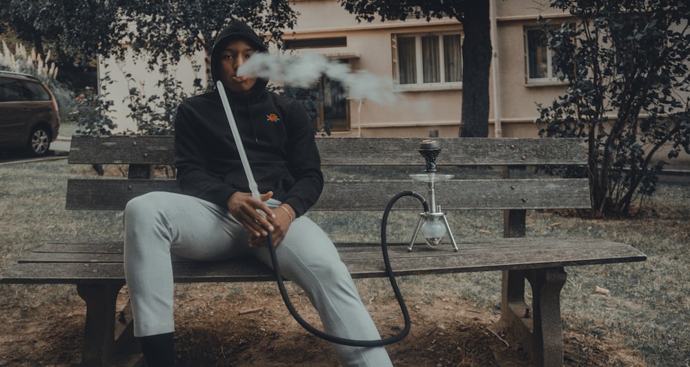 man in black zip up jacket smoking cigarette