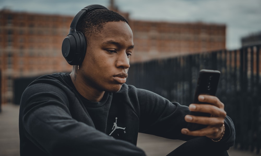 homem em capuz nike preto usando fones de ouvido pretos