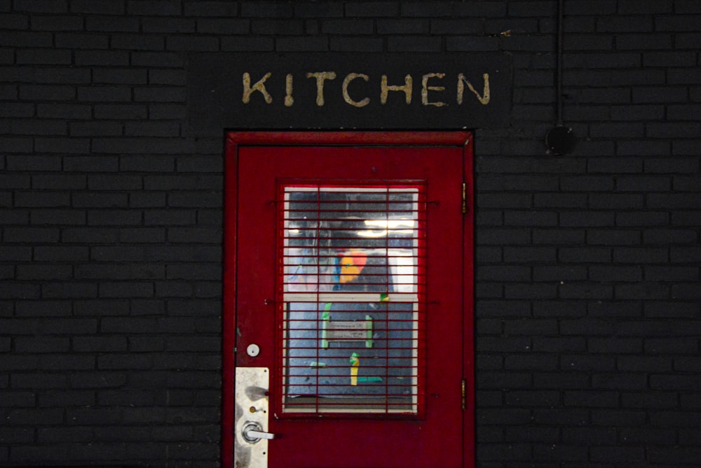 red wooden door with black brick wall