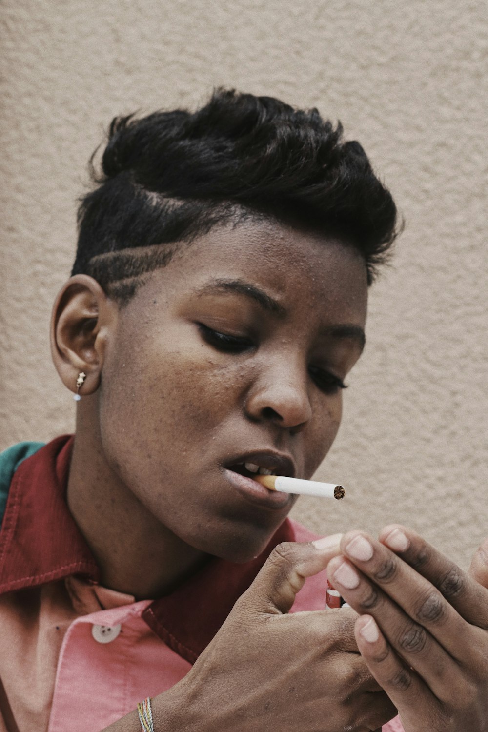 man in red polo shirt smoking