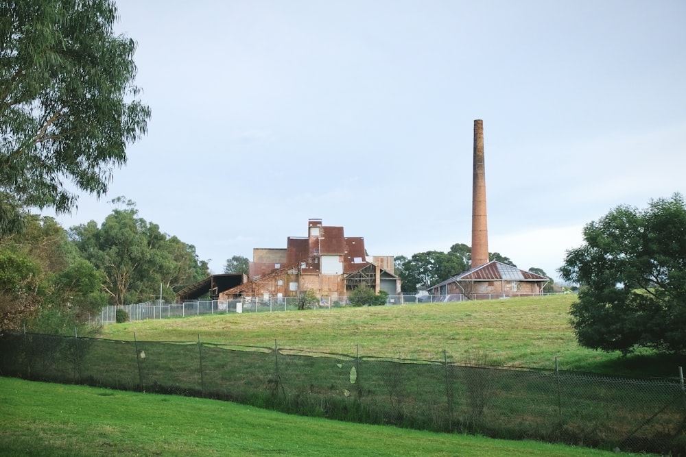 Grünes Grasfeld in der Nähe von braunem Betongebäude tagsüber