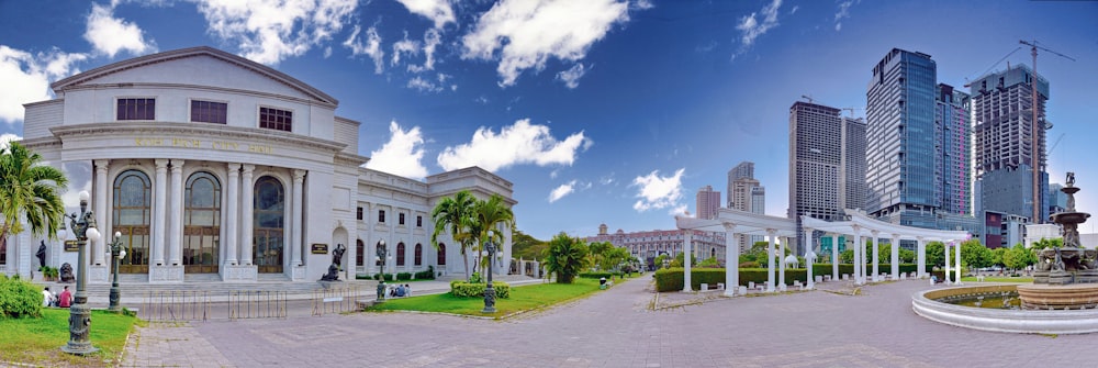 edifício de concreto branco perto do campo de grama verde sob o céu azul durante o dia