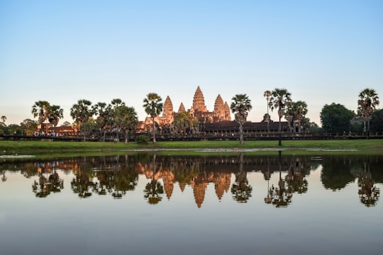 brown and white concrete building near green grass field and body of water during daytime in Angkor Wat Cambodia