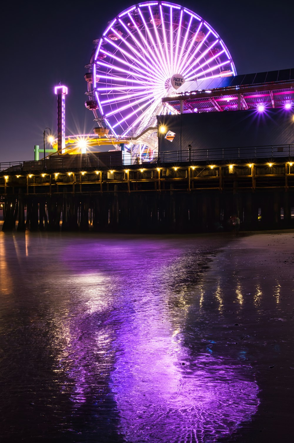 ferris wheel near body of water during night time