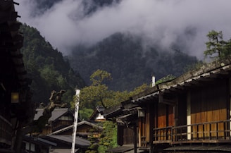 A serene Japanese village with traditional houses surrounded by lush greenery during autumn.