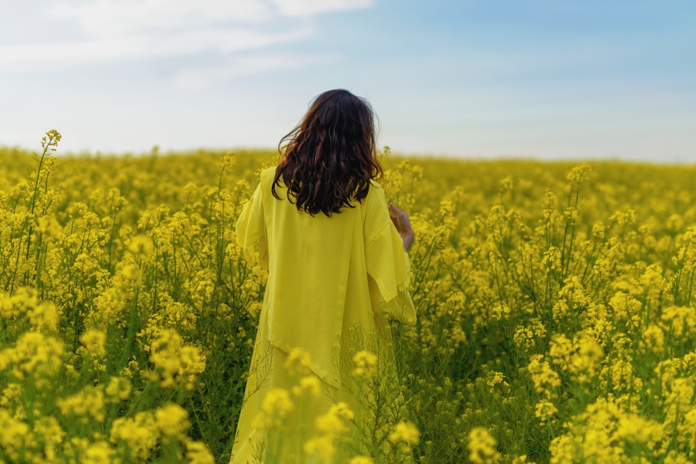 Mujer en el campo de flores amarillas durante el día