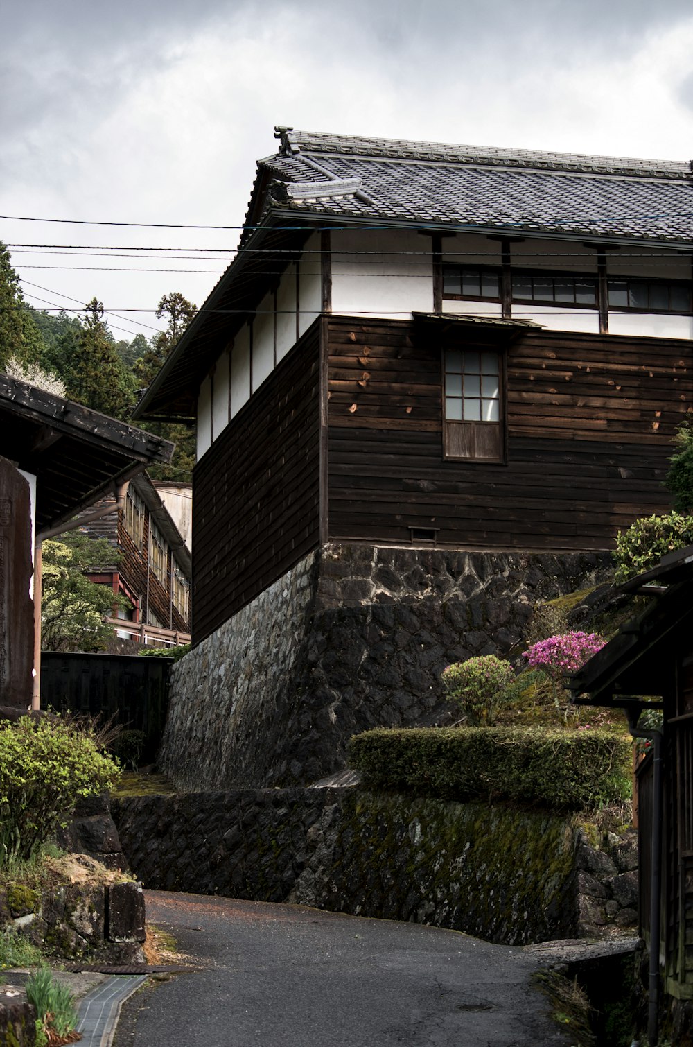 brown wooden house with pink flowers