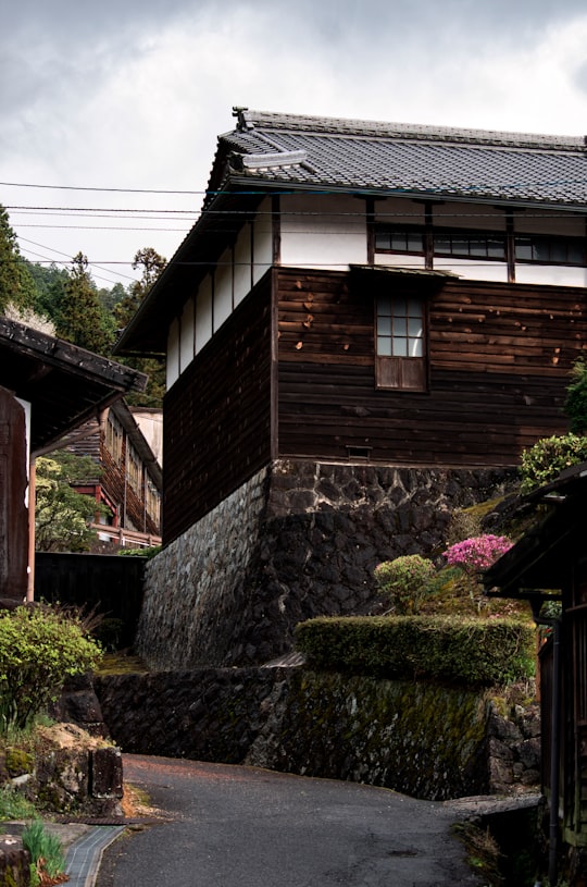brown wooden house with pink flowers in Tsumago Japan