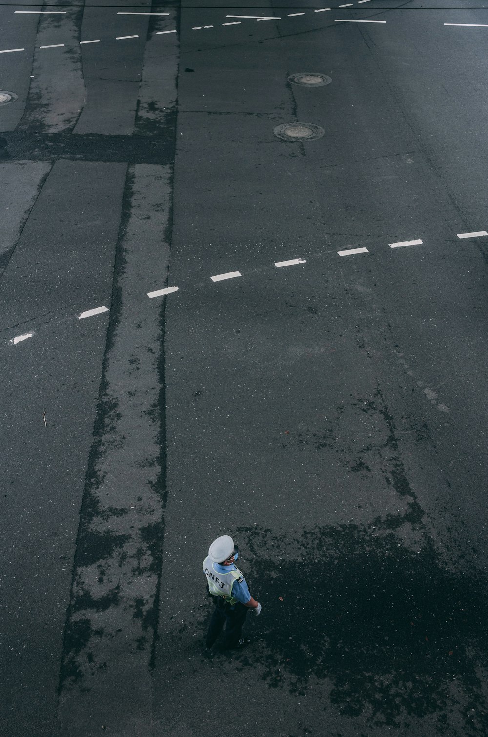 person in blue jacket walking on gray asphalt road during daytime