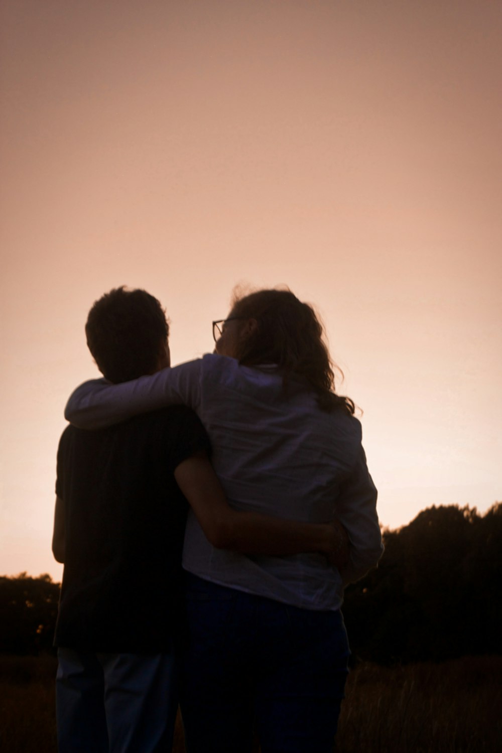 man and woman kissing during sunset