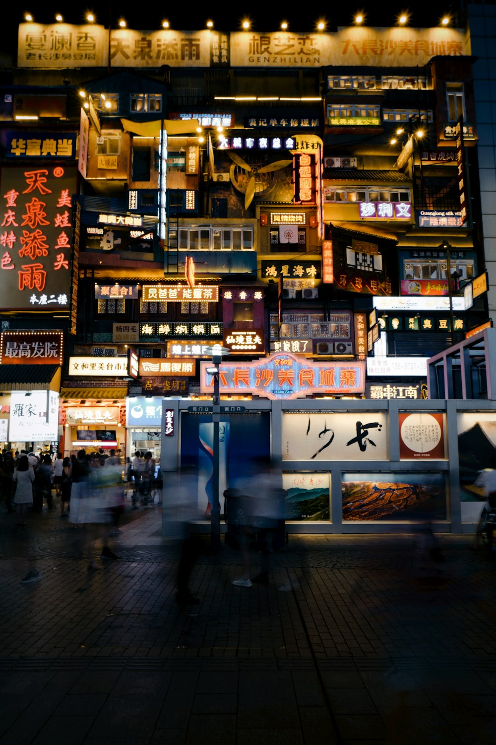 people walking on sidewalk during night time