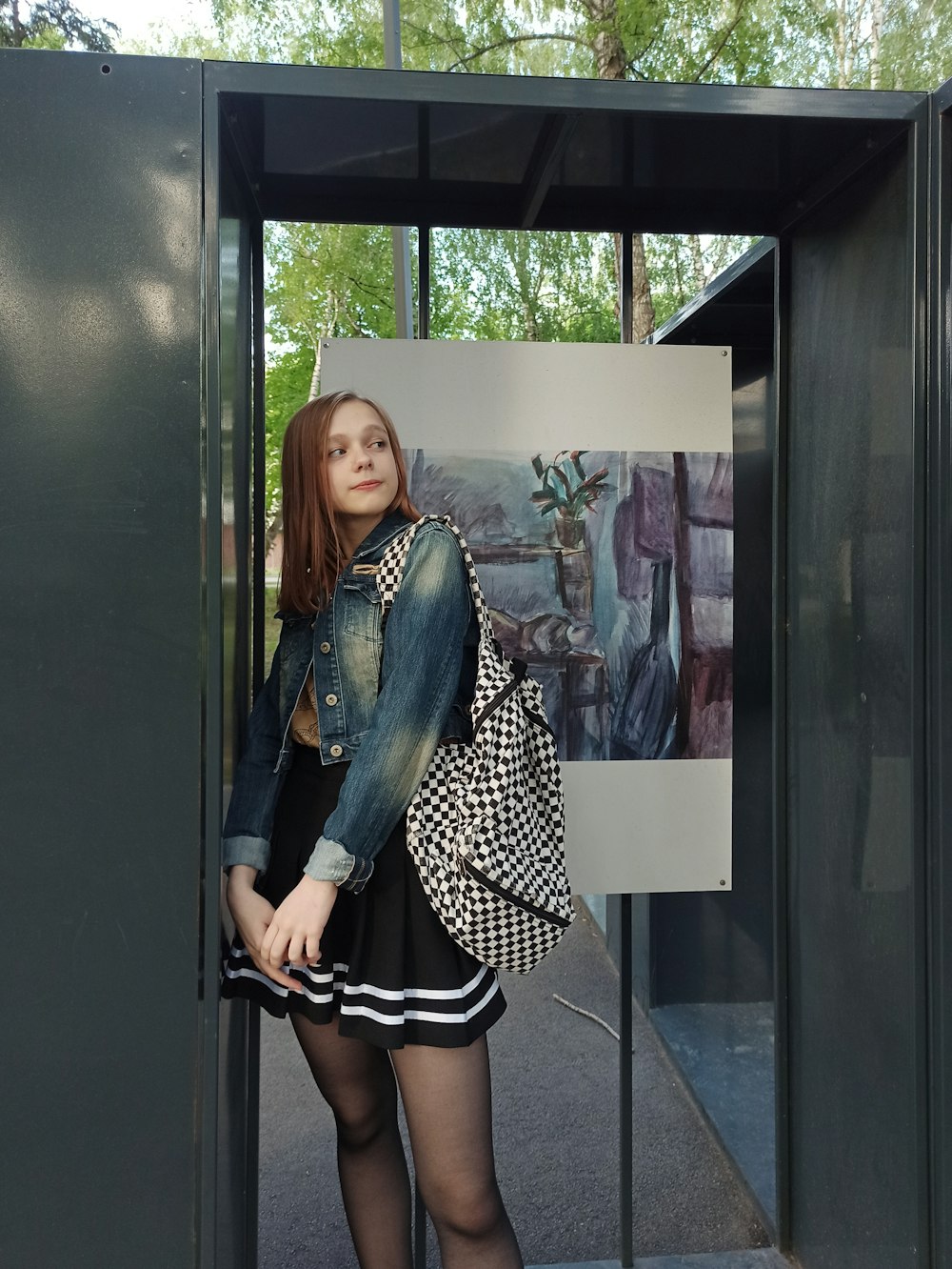 woman in black and white polka dot dress standing beside glass window