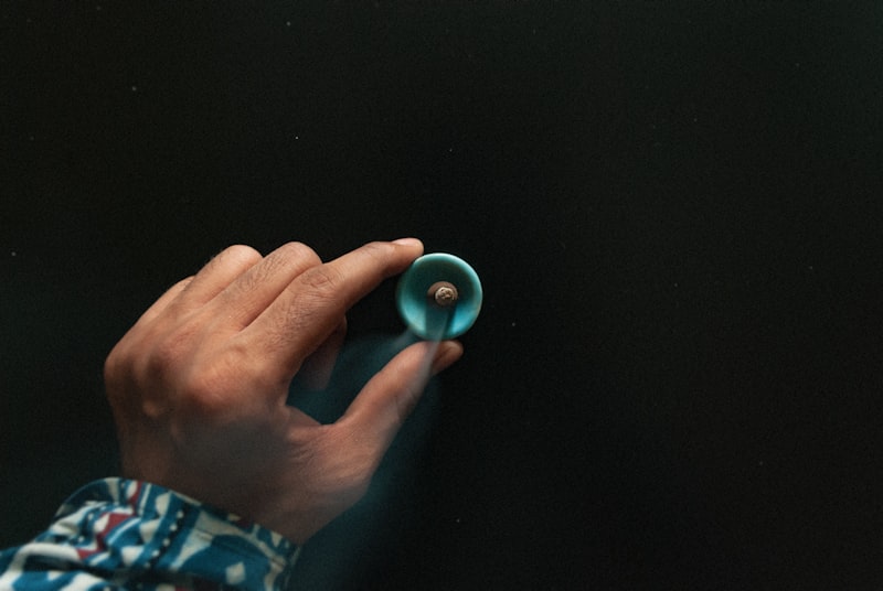 Person holding an incence cone in blue container