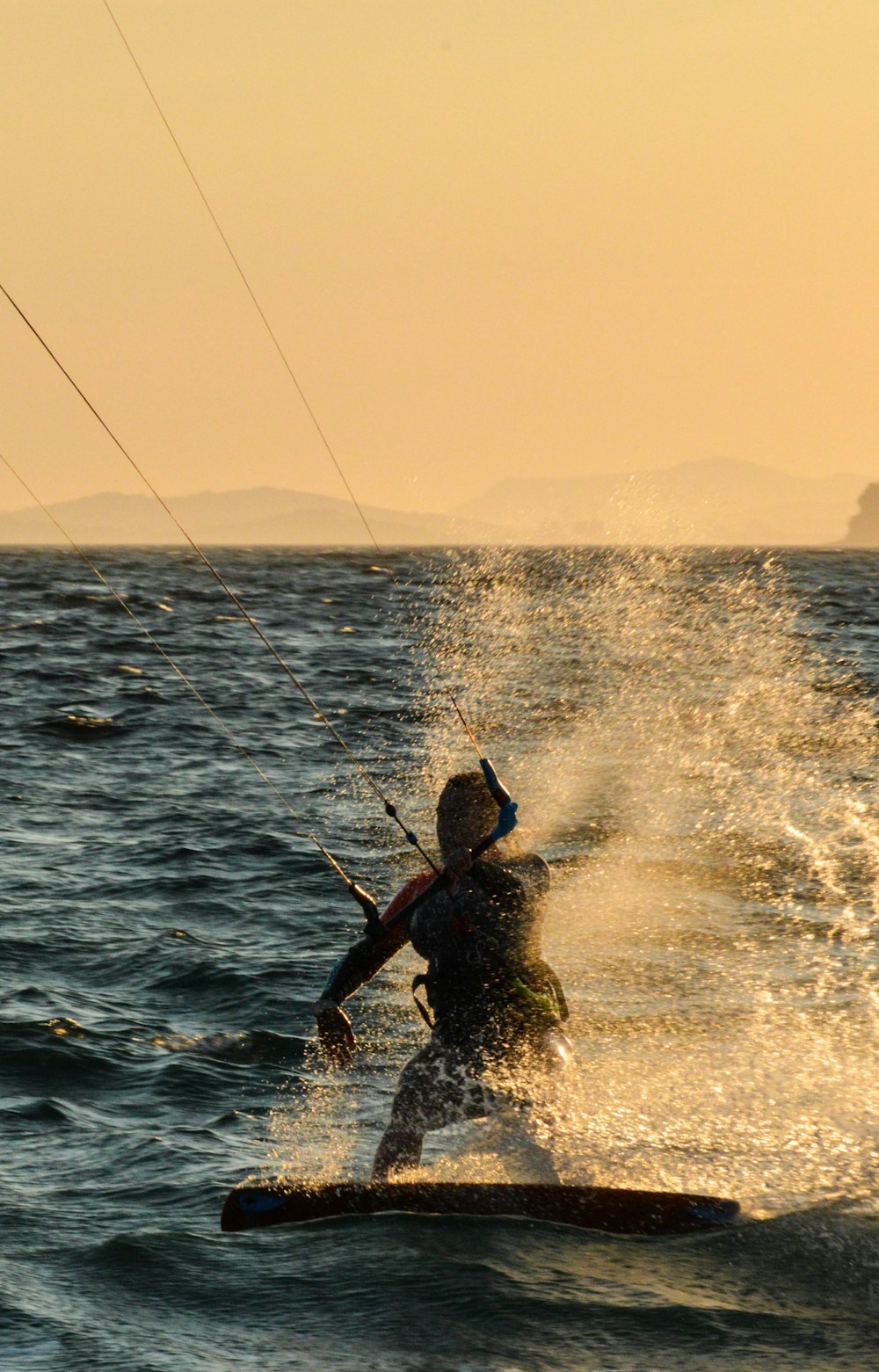 hombre en traje de neopreno negro sosteniendo la caña de pescar en el mar durante el día