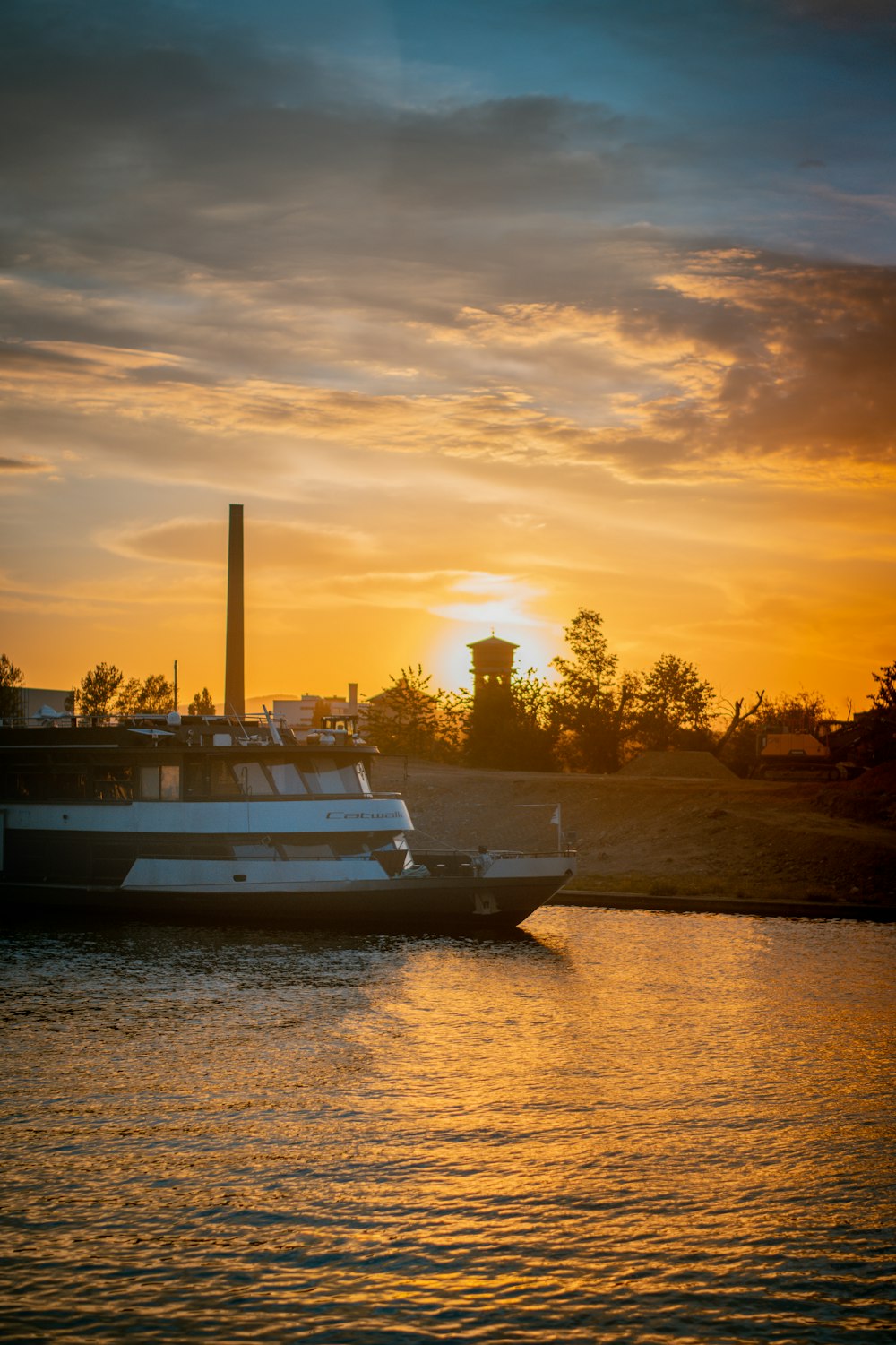 white boat on body of water during sunset