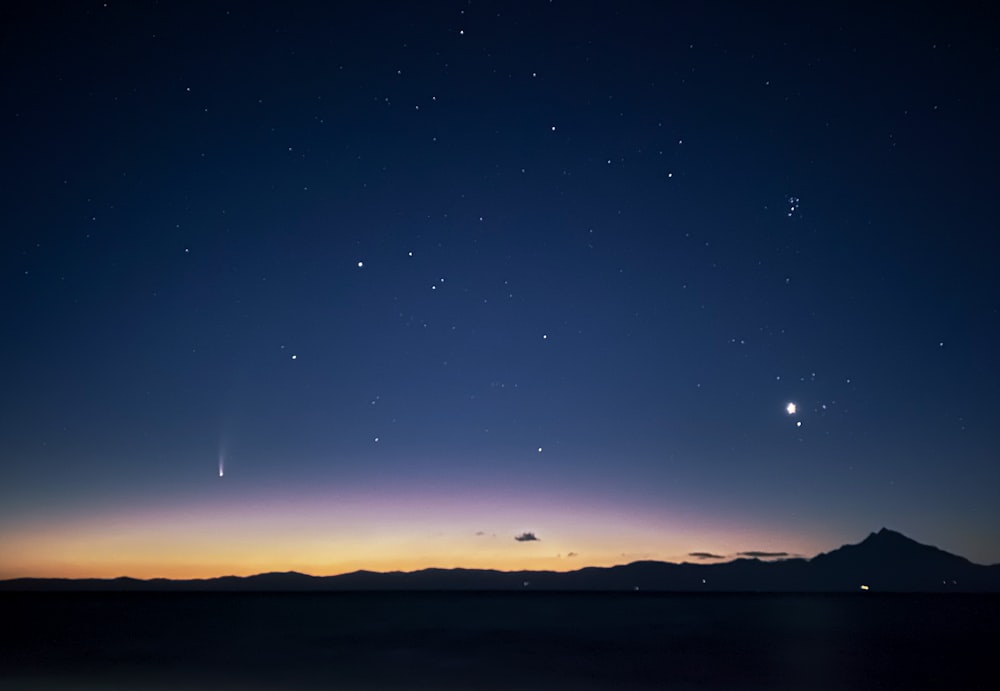 silhouette of mountain during night time