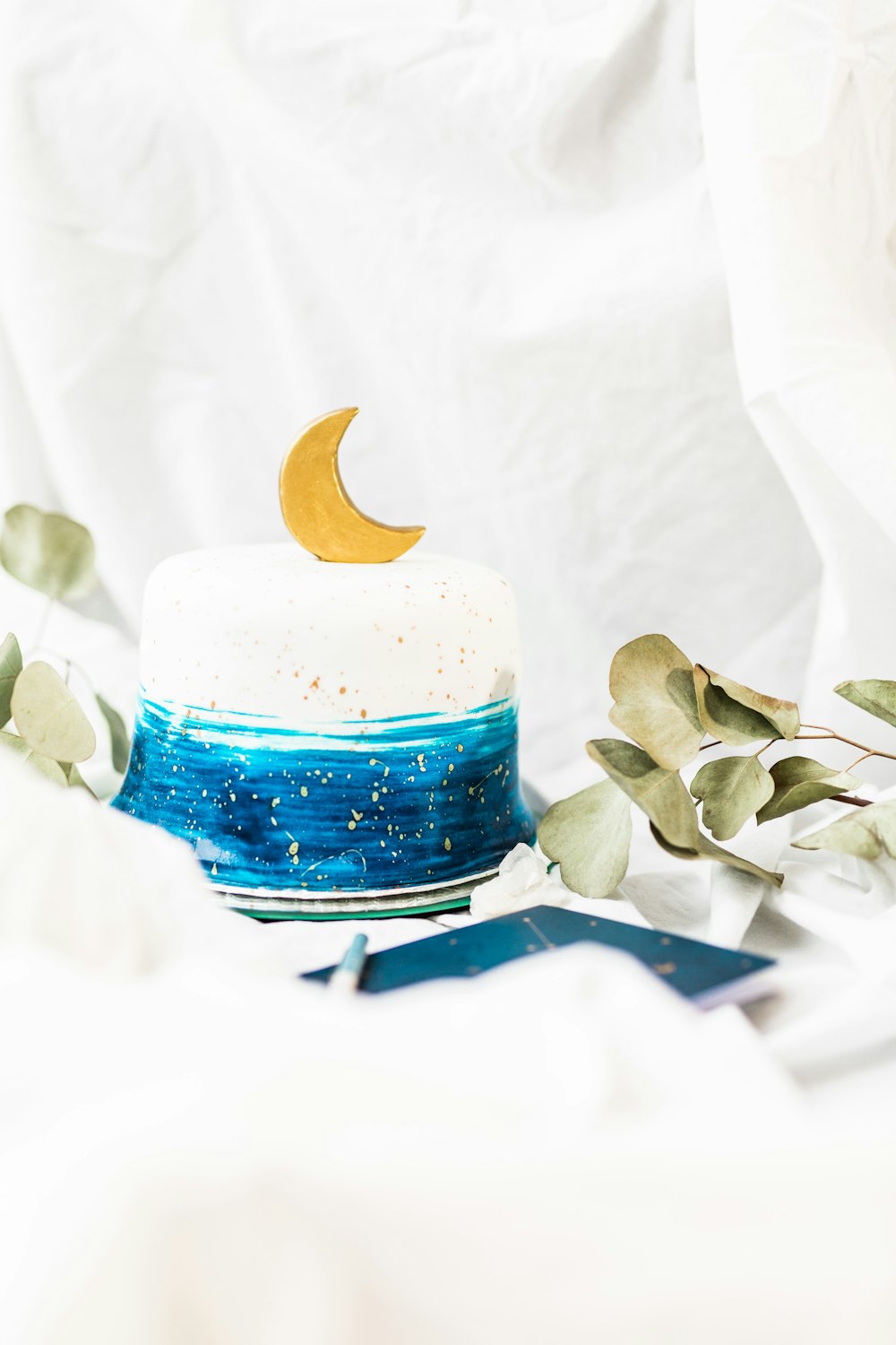 blue and white ceramic jar with white flower petals