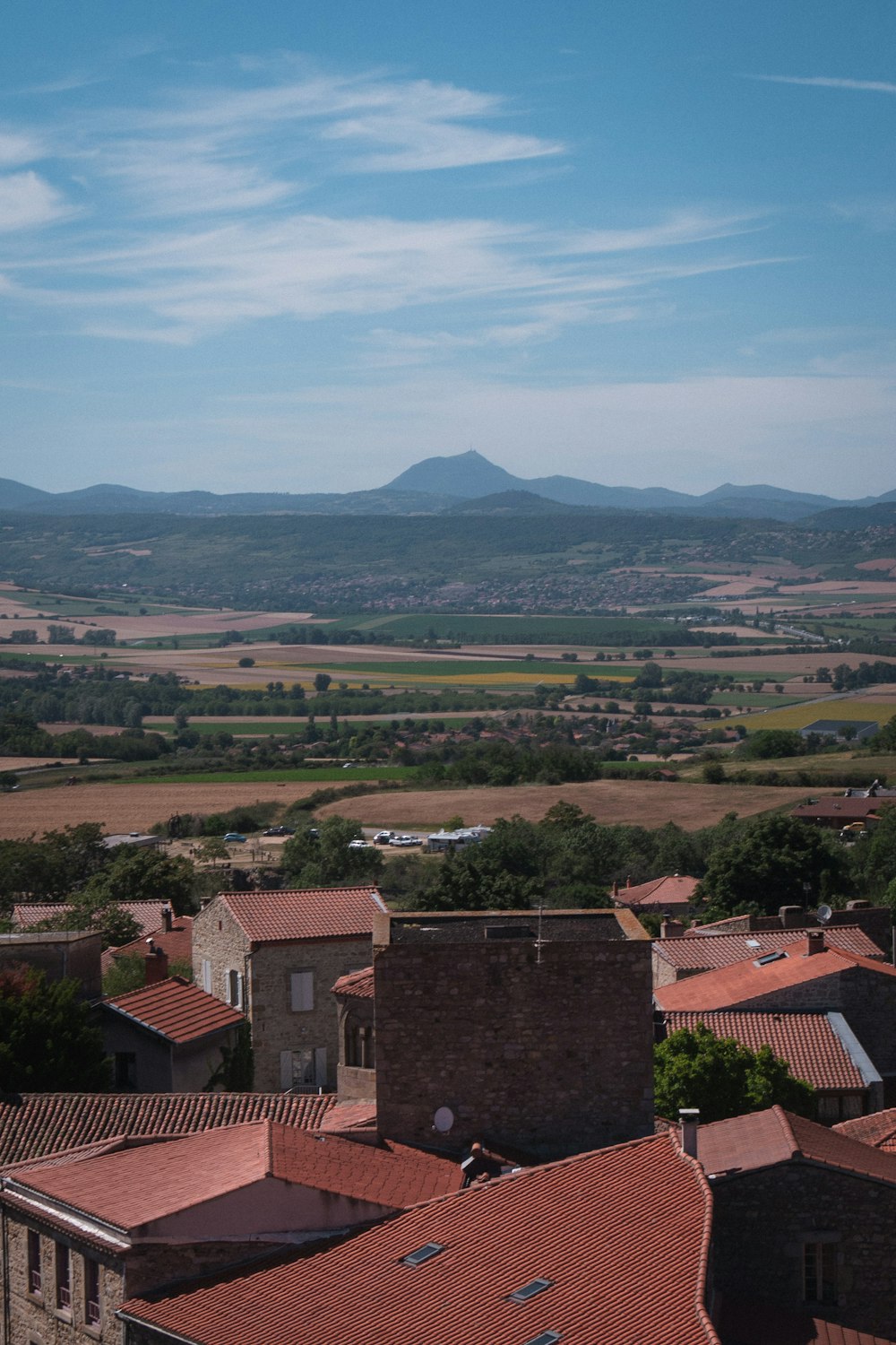 Maisons en béton brun près d’arbres verts et de montagnes pendant la journée