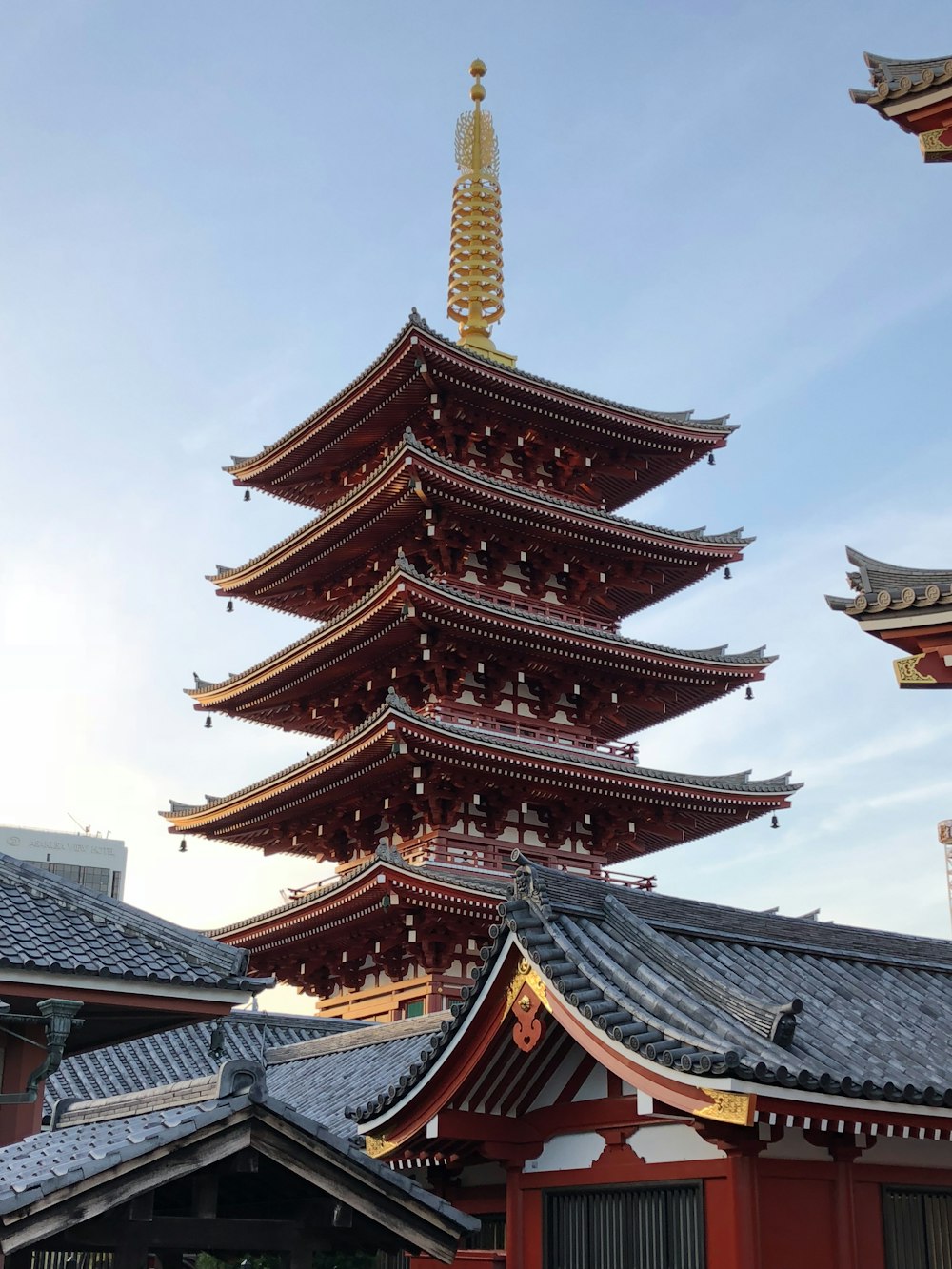 brown and black pagoda temple under white clouds during daytime