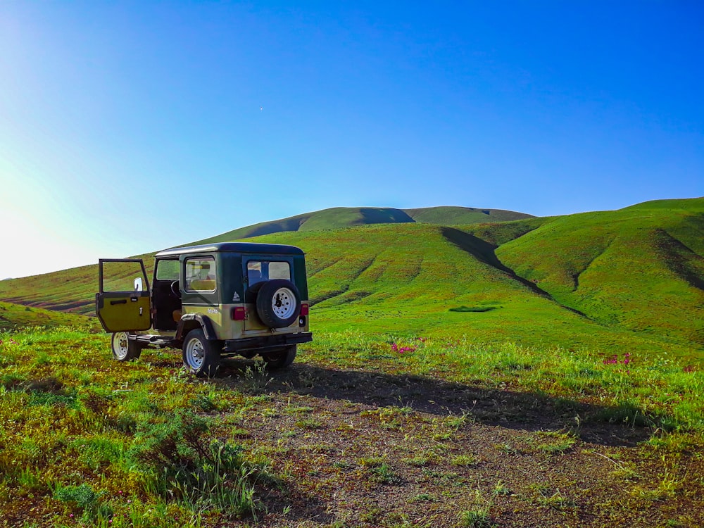 brown and black truck on green grass field under blue sky during daytime